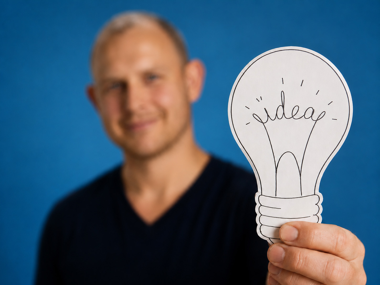 Man houdt een papieren gloeilamp met het woord 'idea' vast — jouw idee voor een app